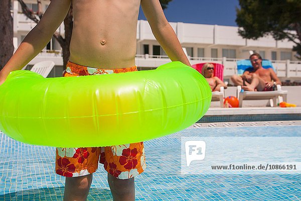 Boy with inflatable at swimming pool