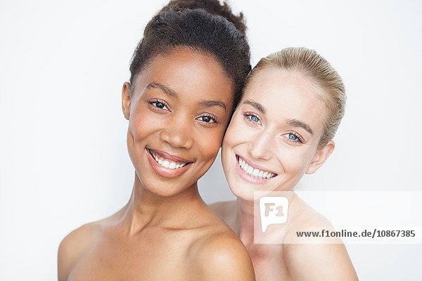 Women with bare shoulders looking at camera smiling