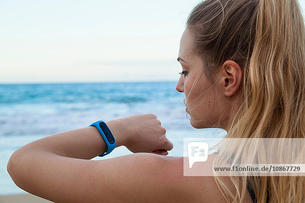 Close up of young female runner checking smartwatch time on beach  Dominican Republic  The Caribbean