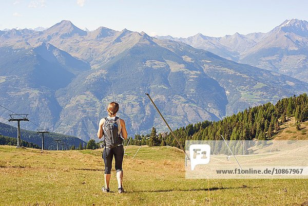 Rückansicht einer Wanderin  die über die Berglandschaft blickt  Aostatal  Aosta  Italien
