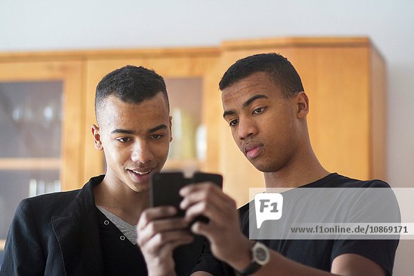 Zwillingsbrüder zu Hause  Blick auf Smartphone