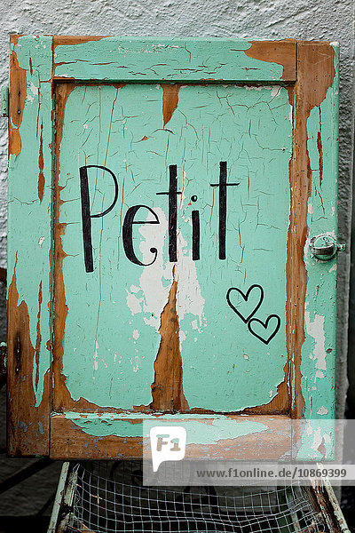 Rustikale grüne Vintage-Tür mit 'Petit'-Schild