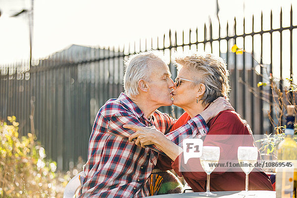 Romantisches Seniorenpaar küsst sich auf dem Dachgarten der Stadt