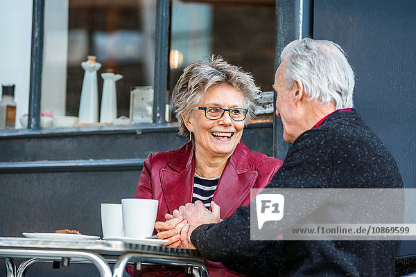 Romantisches älteres Paar hält sich im Straßencafé an der Hand