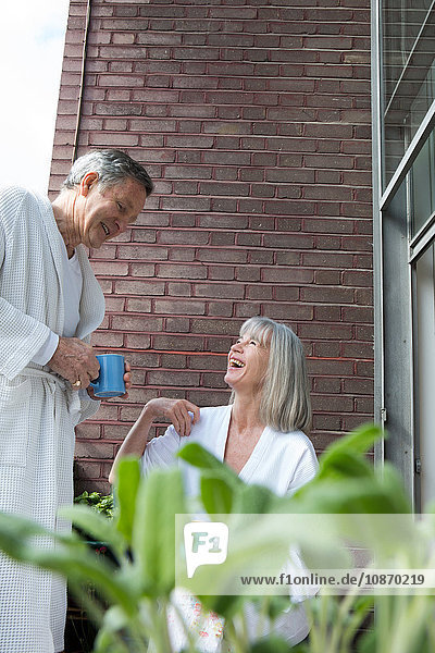 Pärchen plaudern Kaffee auf dem Balkon trinken