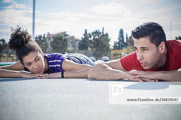 Young man and woman training  taking a break on asphalt