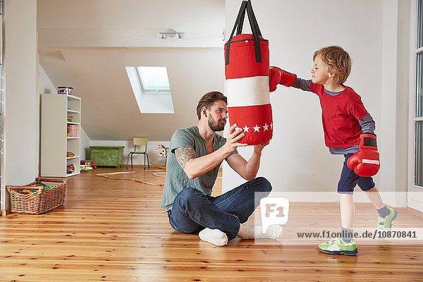 Father holding punchbag for son