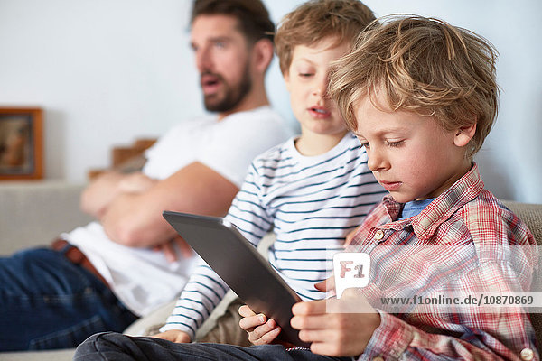 Boys with father using digital tablet
