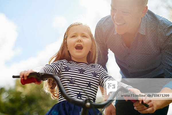 Vater bringt Tochter das Fahrradfahren bei