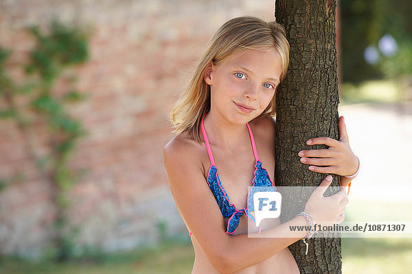 Porträt eines an einen Baum gelehnten Mädchens in Bikini-Oberteil  Buonconvento  Toskana  Italien