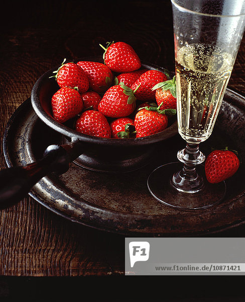 Vintage-Schale mit Erdbeeren und Glas Champagner  auf Zinnteller  Nahaufnahme