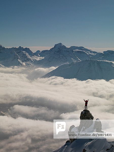 Bergsteiger feiert auf Gipfel  der aus Nebel auftaucht  Bettmeralp  Wallis  Schweiz