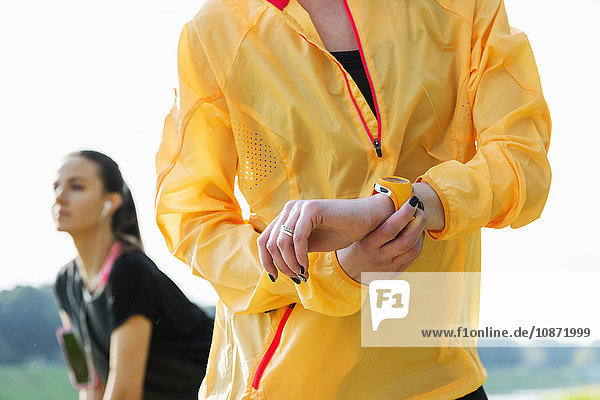 Junge Frau  die einen Aktivitäts-Tracker am Handgelenk trägt  mittlerer Abschnitt