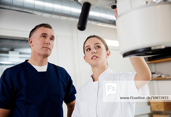 Doctor and nurse adjusting medical x-ray equipment