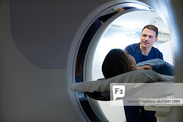 Doctor preparing female patient for CT-scan