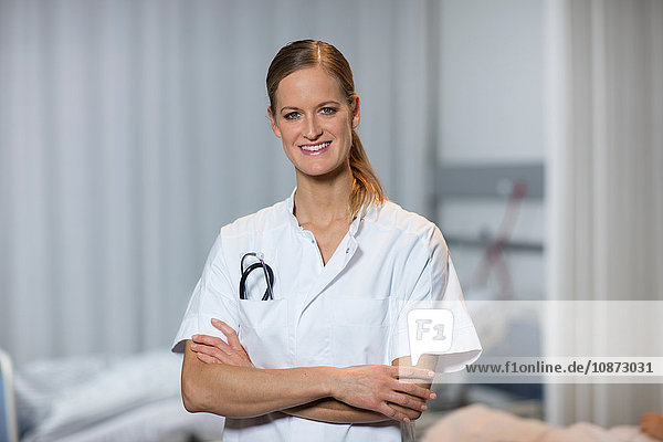 Porträt eines Arztes vor einem Krankenhausbett