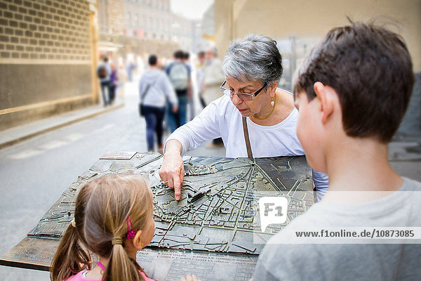 Ältere Frau und Enkelkinder zeigen auf Stadtplan  Florenz  Italien