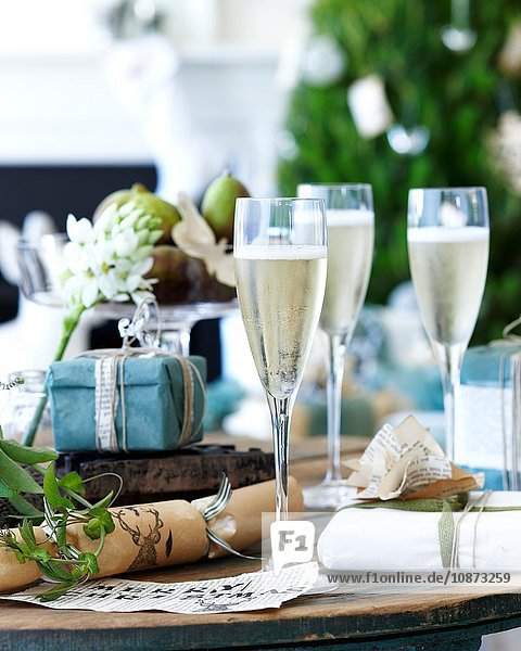 Nahaufnahme eines Champagner-Tisches mit Weihnachtskräckern und Geschenken