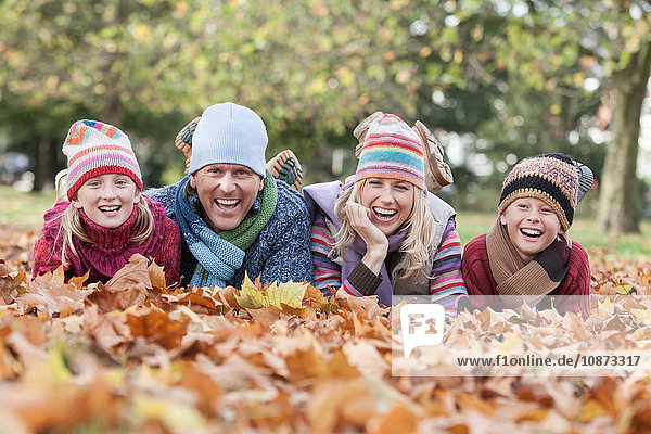Portrait of family  lying in autumn leaves  laughing