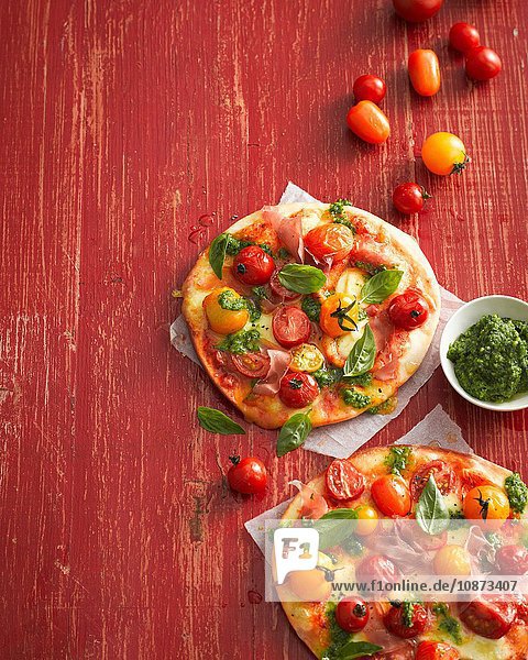 Hochwinkelansicht von Tomaten-  Basilikum- und Schinkenpizzas