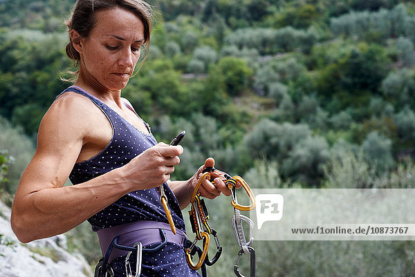 Bergsteigerin bereitet Sicherheitsgurt mit Karabinas vor