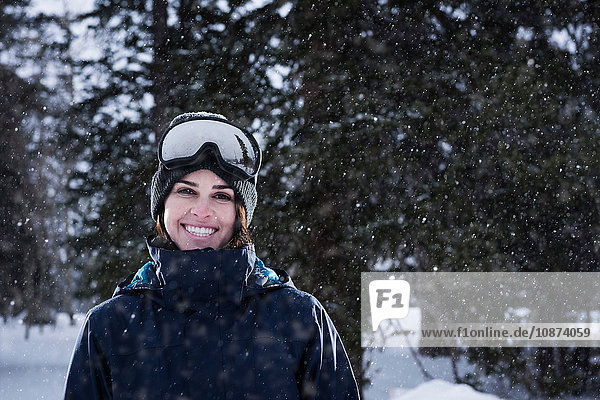 Porträt einer jungen Frau mit Skibrille im Schnee  Brighton Ski Resort ausserhalb von Salt Lake City  Utah  USA