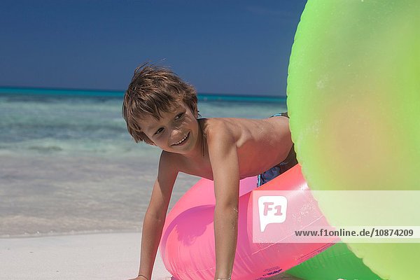 Junge spielt auf aufblasbaren Ringen am Strand  Mallorca  Spanien