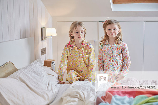 Mädchen in Pyjamas neben dem Bett im Hochbett
