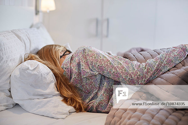 Frau im Schlafanzug schläft im Bett