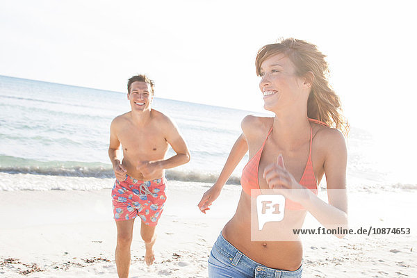 Man chasing girlfriend on beach  Majorca  Spain