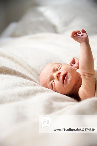Auf einer Decke liegender Junge Augen geschlossen und gestreckt