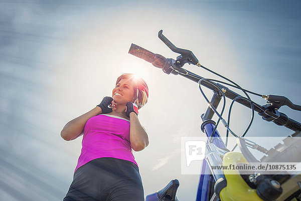 Frau mit Mountainbike,  die ihren Helm aufsetzt,  Kanton Wallis,  Schweiz