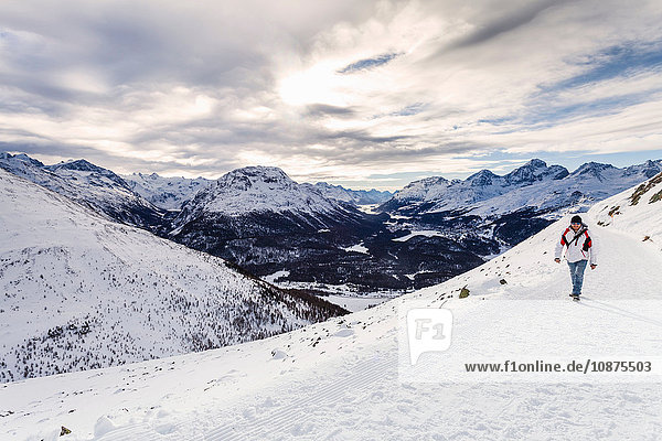 Mann zu Fuss auf schneebedecktem Berg  Rückansicht  Engadin  Schweiz