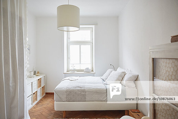 Weiß gefärbtes Schlafzimmer mit Parkettboden  Bett und Schränken