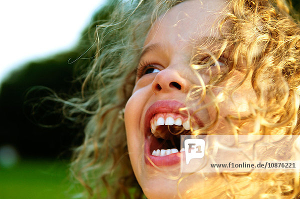 Close up of blond curly haired girl laughing