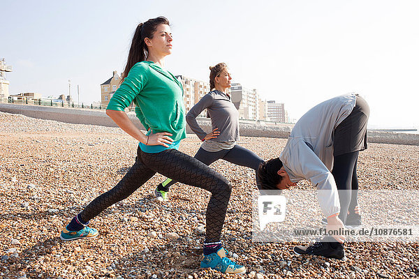 Aufwärmtraining für Männer und Frauen  Stretching am Strand von Brighton