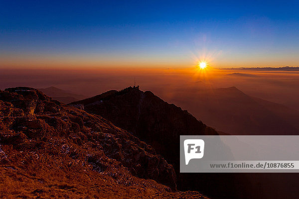 Erhöhte Silhouettenlandschaft mit Talnebel bei Sonnenuntergang  Monte Generoso  Tessin  Schweiz