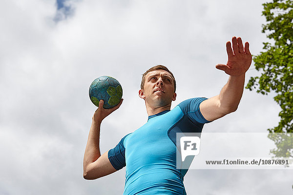 Low angle view of young male handball player preparing to throw ball