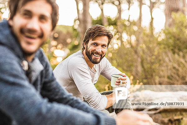 Zwei Männer trinken Kaffee während sie im Wald sitzen Deer Park Kapstadt Südafrika