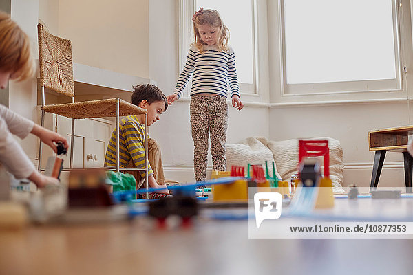 Junges Mädchen und Junge spielen mit einer Spielzeugeisenbahn