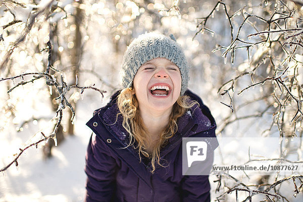 Porträt eines lachenden jungen Mädchens in verschneiter Landschaft