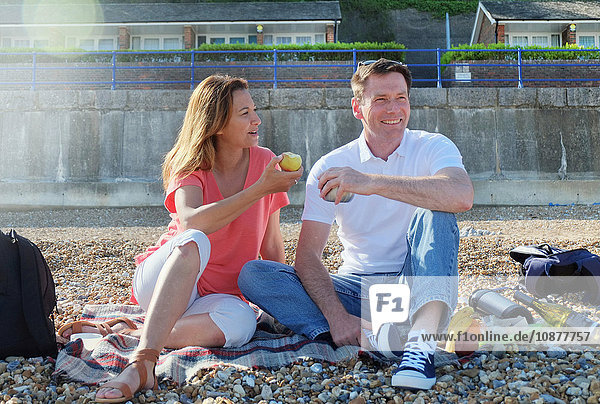 Couple having picnic on shingle beach
