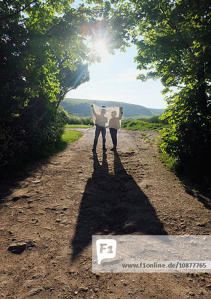 Paar wandert auf Feldwegen und liest Karte