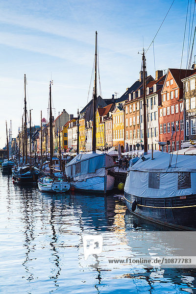Traditionelle mehrfarbige Stadthäuser und festgemachte Boote am Kanalufer  Kopenhagen  Dänemark