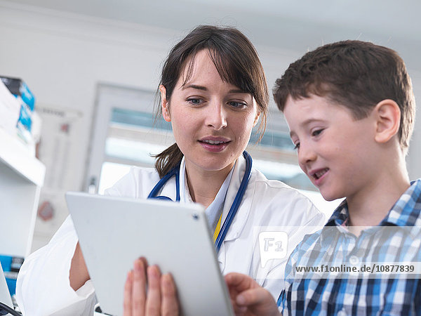 Arzt und Junge mit digitalem Tablett