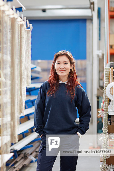 Portrait of young female worker in roller blind factory