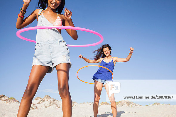 Frauen am Strand mit Hula-Hoop-Reifen