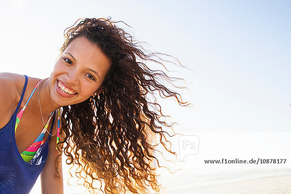 Portrait of curly haired woman looking at camera smiling