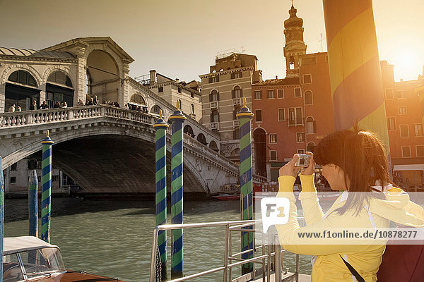 Junge Frau fotografiert die Rialto-Brücke am Canal Grande  Venedig  Italien
