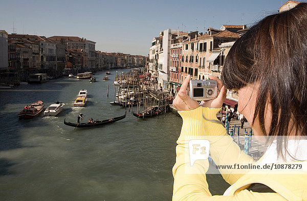Junge Frau beim Fotografieren von Kanalgondeln  Venedig  Italien